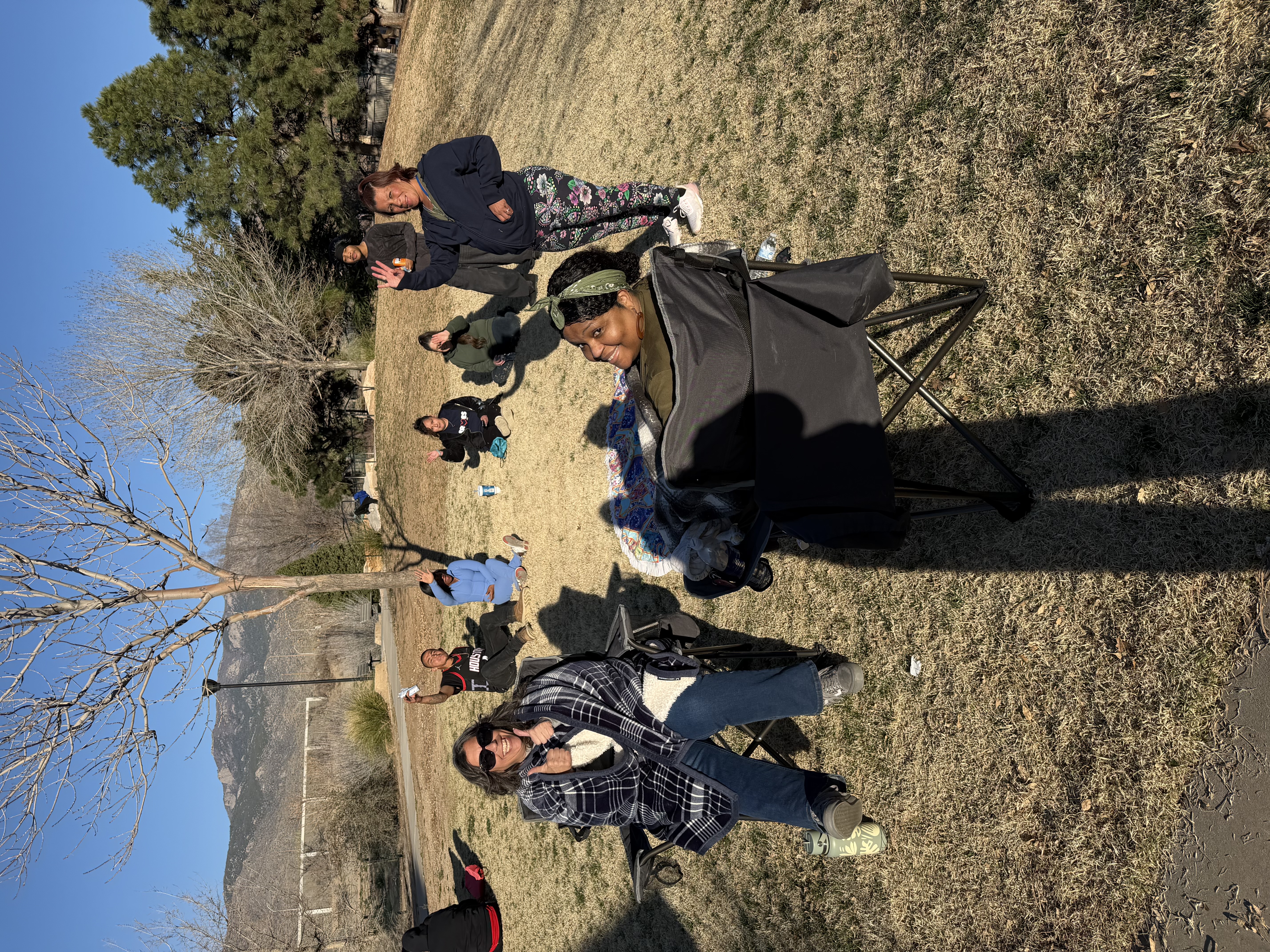 Community members relaxing at the park with Sandia Mountains